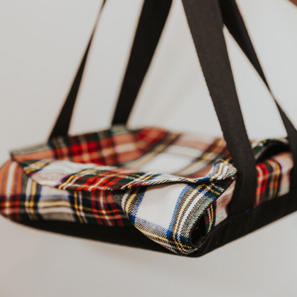 A plaid bag hanging from a hook, reminiscent of a Homespun Tartan Blanket/Throw.