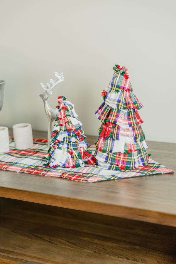 Two Tartan Christmas Trees - Homespun Wool-Blend on a wooden table.