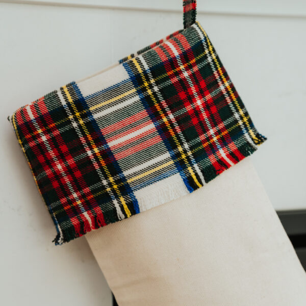 A Tartan Stocking with Toes - Homespun Wool Blend hanging on a mantle.