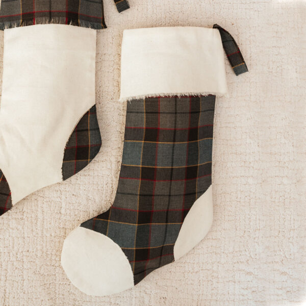 Two Outlander Tartan Toes stockings on a white blanket.