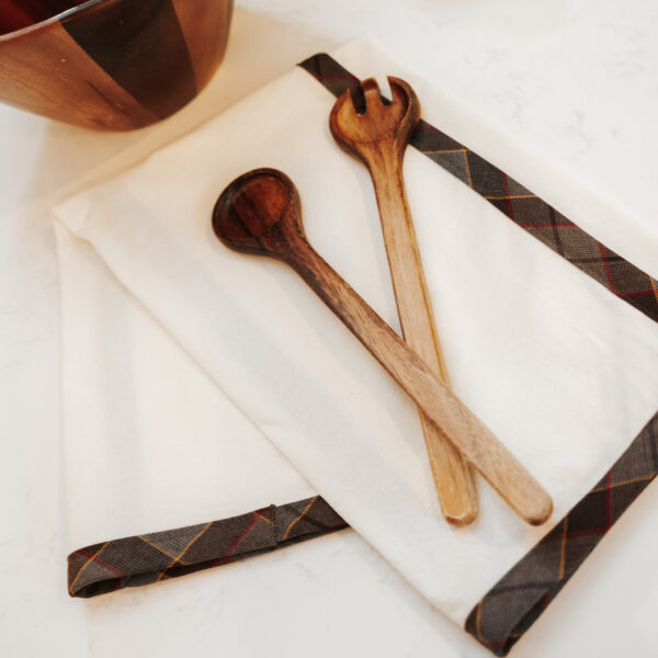 Two wooden spoons and a napkin on a table with a Homespun Tartan Blanket/Throw draped.