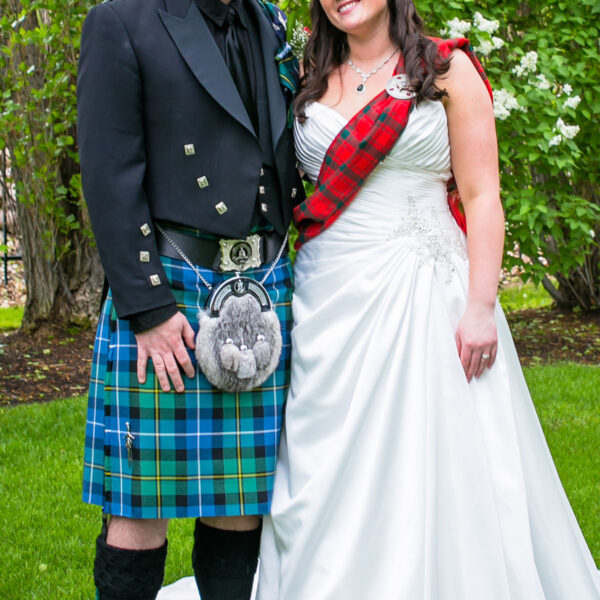 A bride and groom in kilts, wearing 9 Yard Medium Weight 13oz Premium Wool Formal Kilts, posing for a photo.