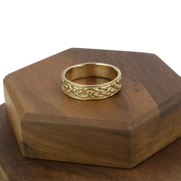 A Women's 10K Gold Claddagh Wedding Ring - Size 7* with a claddagh design resting on top of a wooden box.