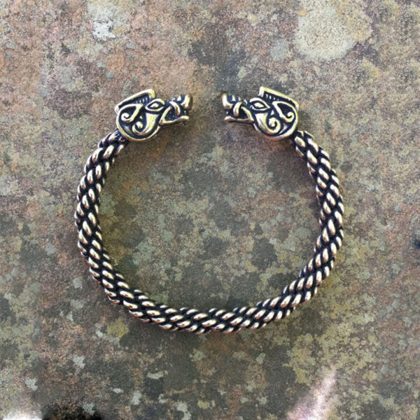 A Celtic Boar Torc Bracelet adorned with two viking heads.