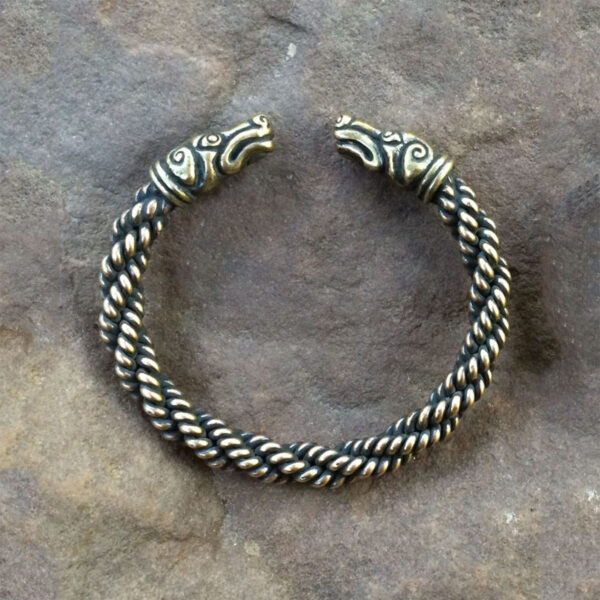 A Celtic Greyhound Torc Bracelet with a viking head on it.