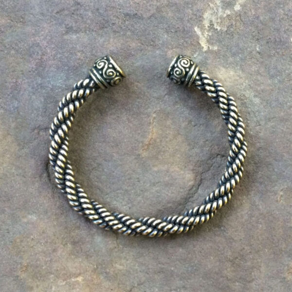 A Celtic Spiral Torc Bracelet on a stone.