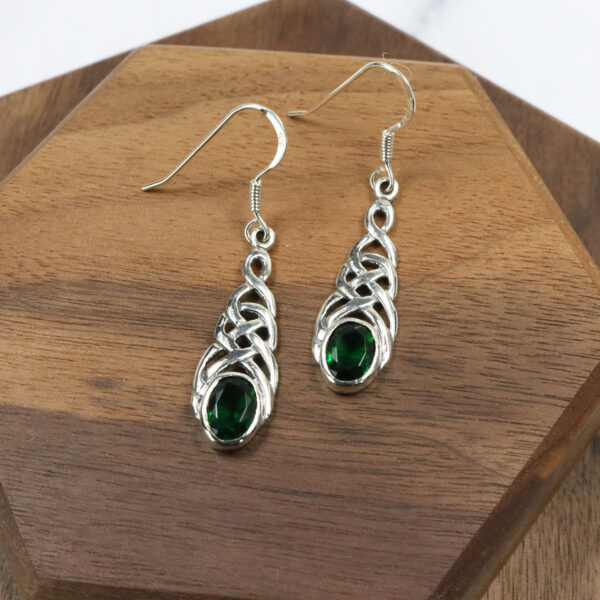 Triquetra sterling silver earrings featuring emerald accents.