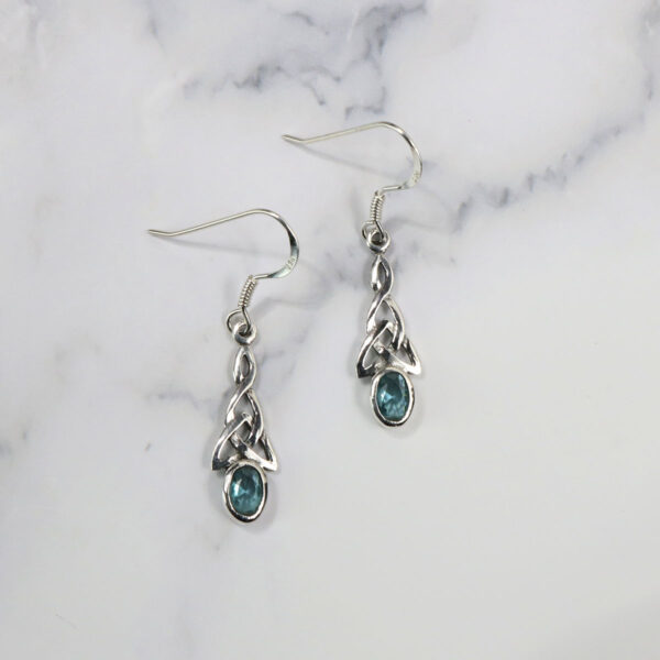 A pair of Triquetra Sterling Silver Earrings with blue topaz stones.