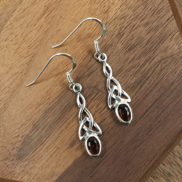 A pair of Triquetra Sterling Silver Earrings with garnet stones.