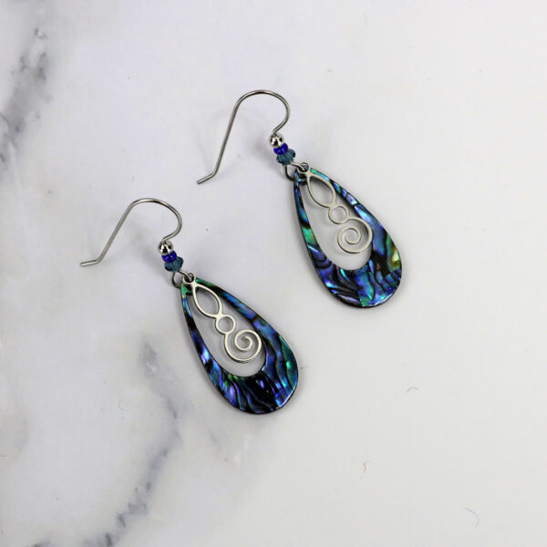 A pair of Celtic Spiral Paua Shell earrings with a black and blue design.