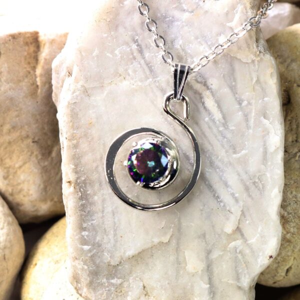 A silver spiral necklace with a multi colored topaz stone and Celtic Knot Emerald Earrings design.