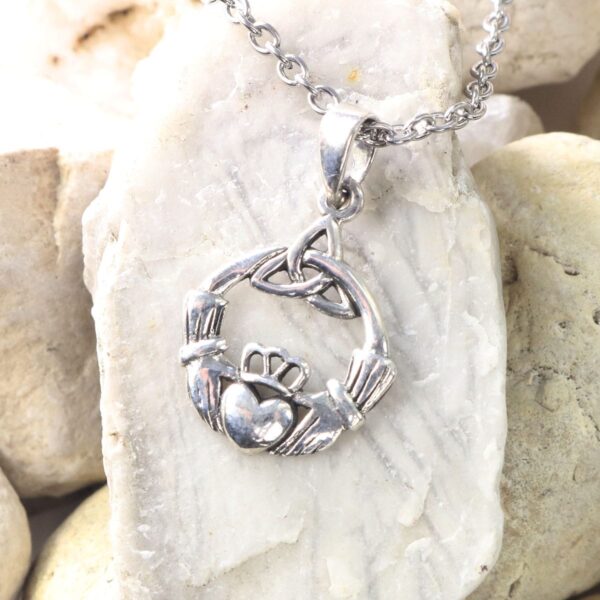 A silver claddagh necklace with a heart and Celtic Knot Emerald Earrings design.