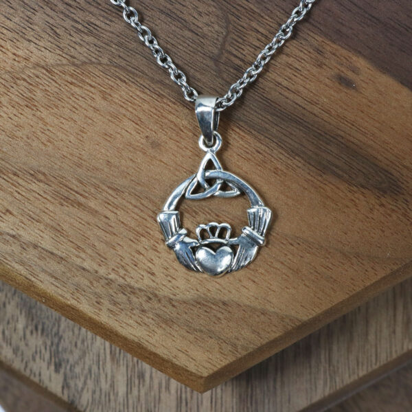 An Amethyst Celtic Knot Necklace with a Celtic Knot design on a wooden table.