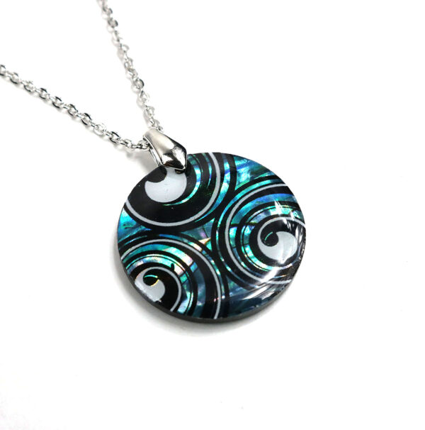 A Triskelion Spiral Paua Shell necklace with black and white swirls.