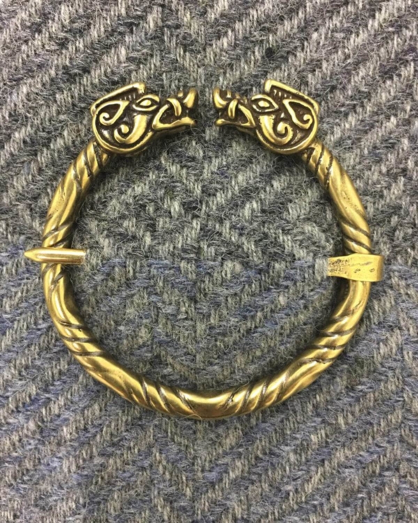 A gold bracelet with two dragon heads on it.