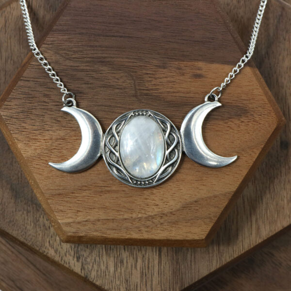 An Amethyst Celtic Knot Necklace with three moon phases on it.