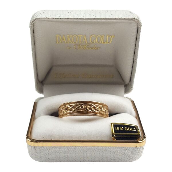 A gold ring with a celtic design in a box.
