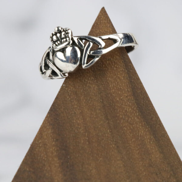 A silver claddagh ring with a heart on top and a Two Tone Eternity Knot Band.