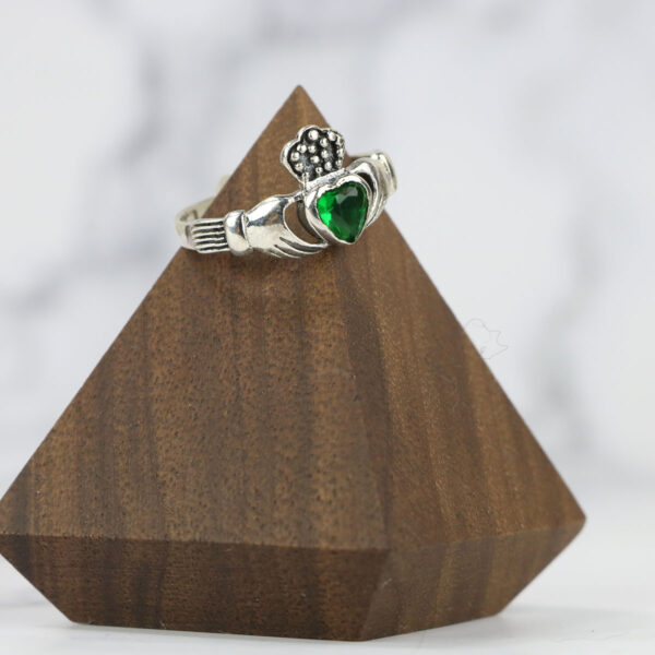 A Large Celtic Knot Spinner Ring with an emerald stone, featuring a Celtic knot design.