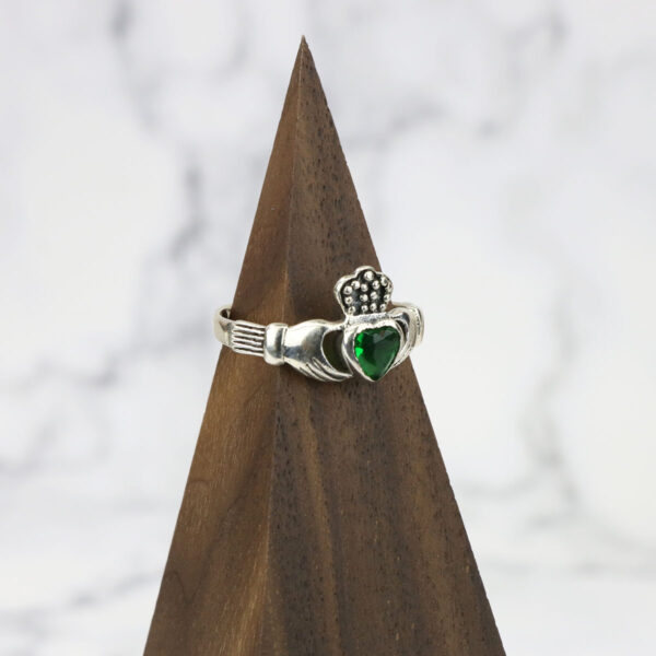 A large Celtic Knot Spinner Ring adorned with a beautiful emerald heart.