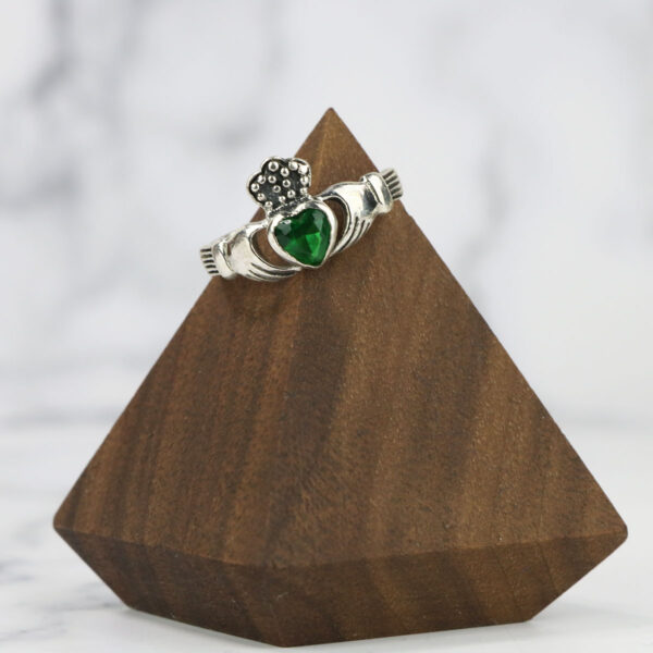 A Large Celtic Knot Spinner Ring with an emerald stone and a claddagh symbol.