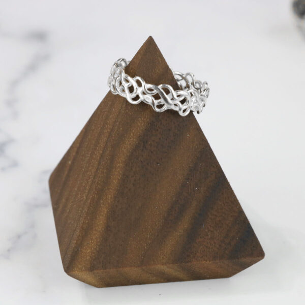 A silver Tangled Celtic Knot Ring on top of a wooden pyramid.