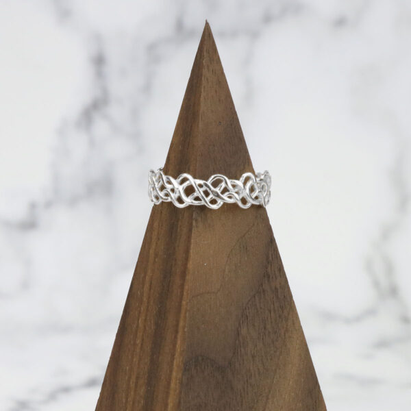 A *Tangled Celtic Knot Ring* resting on top of a wooden block.