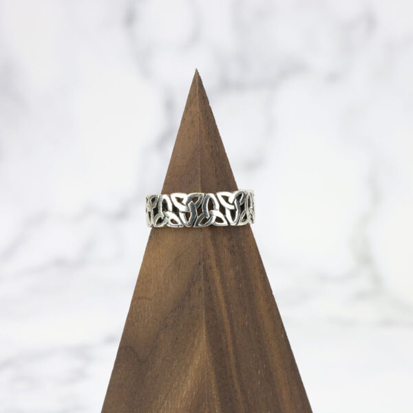 A Large Celtic Knot Spinner Ring on top of a wooden pyramid.