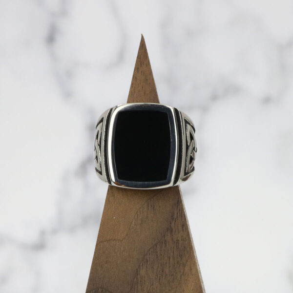 A Black Onyx Stainless Steel Triquetra Ring with a black onyx stone on top.