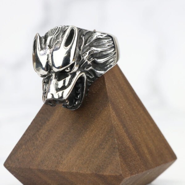 A Dire Wolf Stainless Steel Ring, mounted on a wooden base.