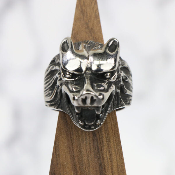 A silver Dire Wolf Stainless Steel ring on a wooden base.