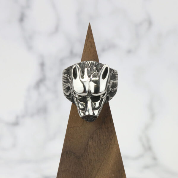 A Dire Wolf Stainless Steel Ring on top of a wooden base.