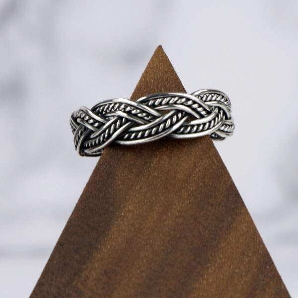A Two Tone Eternity Knot Band with a braided pattern.