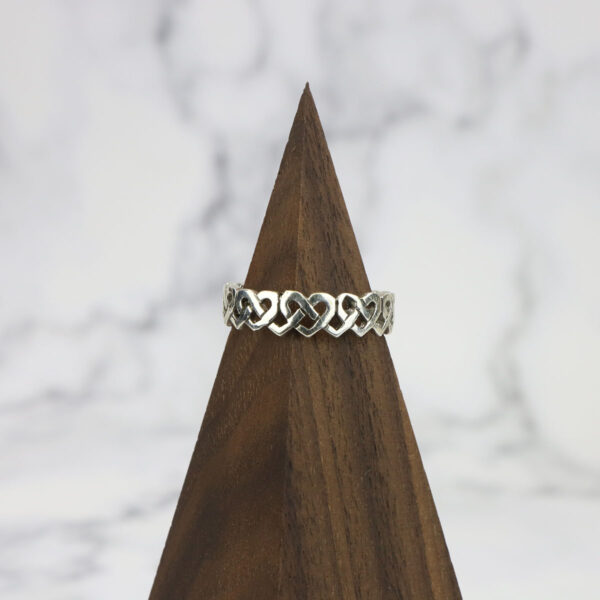 A Large Celtic Knot Spinner Ring on top of a wooden pyramid.