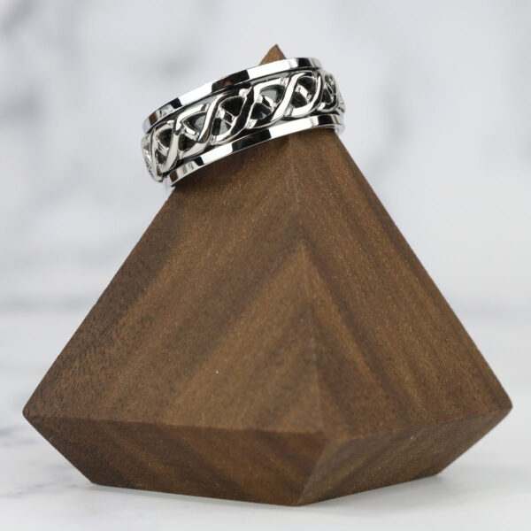 A wooden pyramid with a Celtic Knot Spinner Ring-Size 13* on top.
