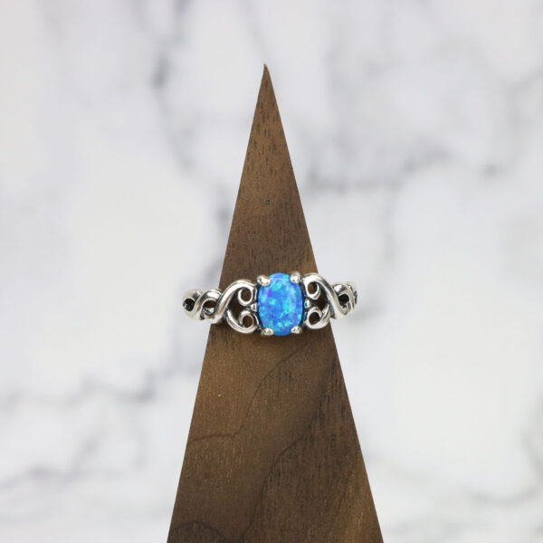 A Large Celtic Knot Spinner Ring with a blue opal in the middle.
