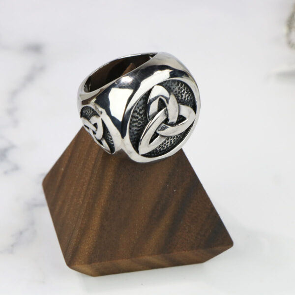 A stainless steel triple triquetra ring with a celtic knot.