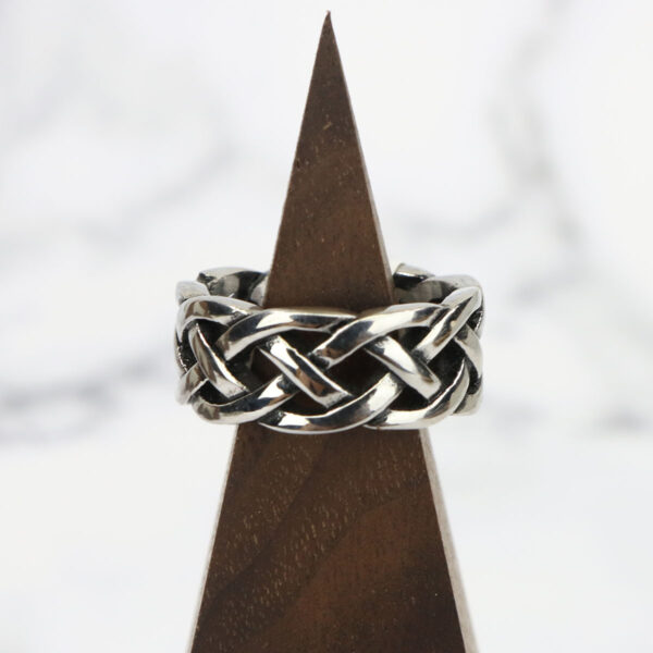An Interlacing Endless Knot Ring with a braided pattern on top.