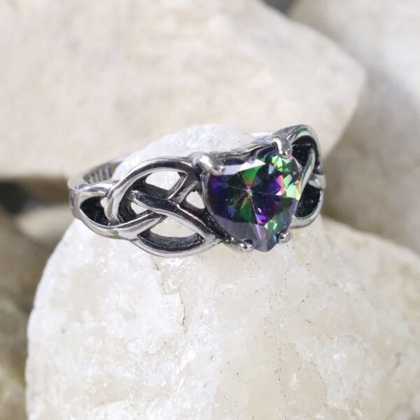 A Mystic Crystal Celtic Knot Heart Ring adorned with a rainbow crystal.