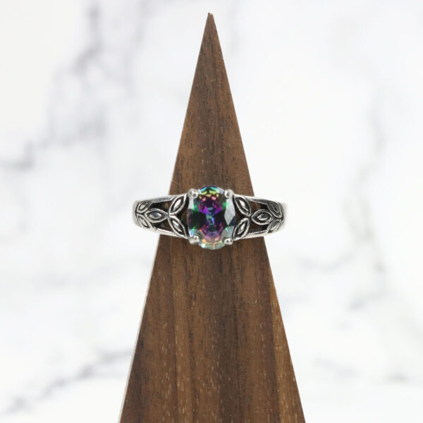 A Mystic Crystal Stainless Steel Ring with a multi colored stone on top.