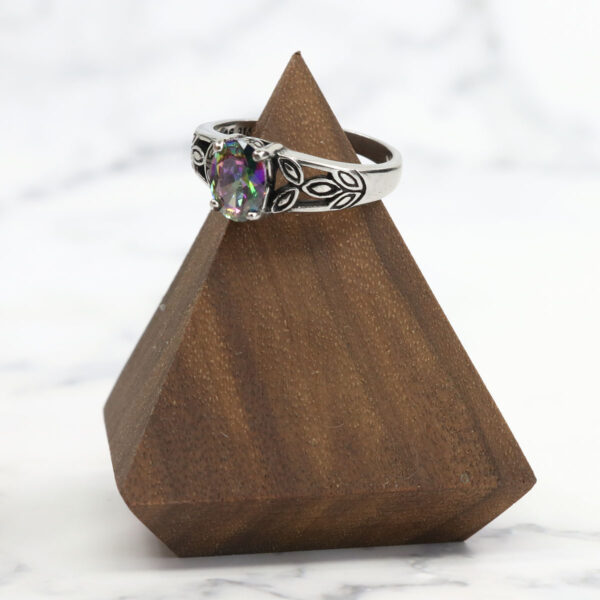 A Mystic Crystal Stainless Steel Ring resting on top of a wooden pyramid.