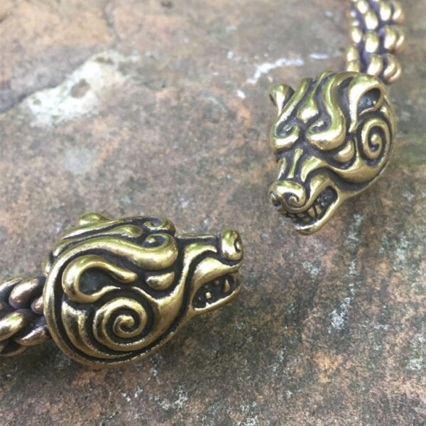 A pair of Celtic Bear Torc - Heavy braid bracelets on a rock.