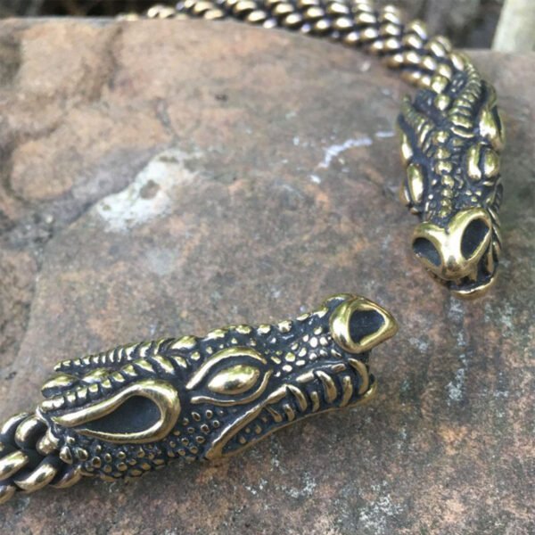 Celtic Dragon Neck Torc bracelets on a rock.