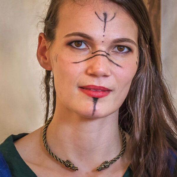 A woman donning a Celtic Dragon Neck Torc necklace and viking-inspired face paint.