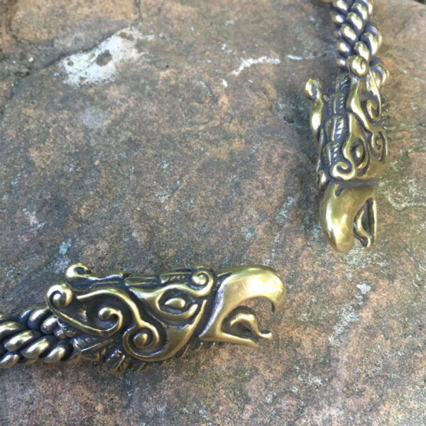 A Celtic Griffin Neck Torc resting on a rock.