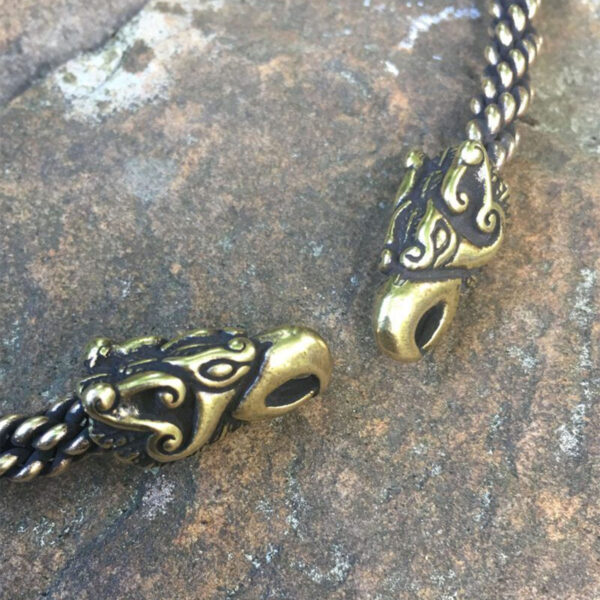 A pair of brass dragon head beads on a Celtic Griffin Neck Torc.