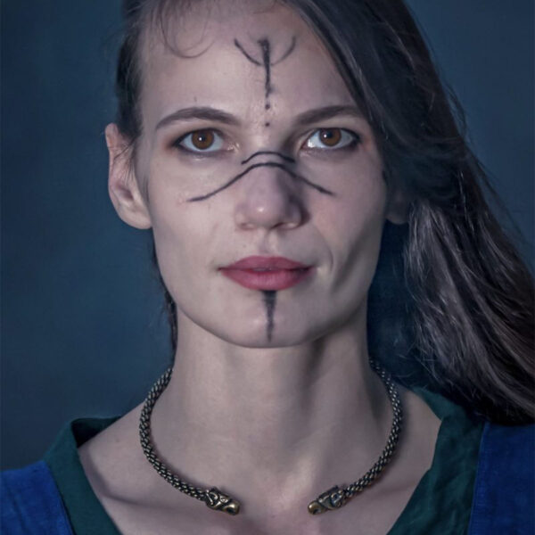 A woman adorned with a Celtic Griffin Neck Torc, proudly displaying a viking face painted on her face.