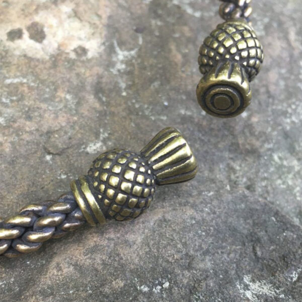 A pair of braided brass beads adorned upon a Celtic Thistle Neck Torc.