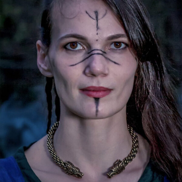 A woman adorned with Viking tattoos and wearing a Celtic Wolf Neck Torc necklace.