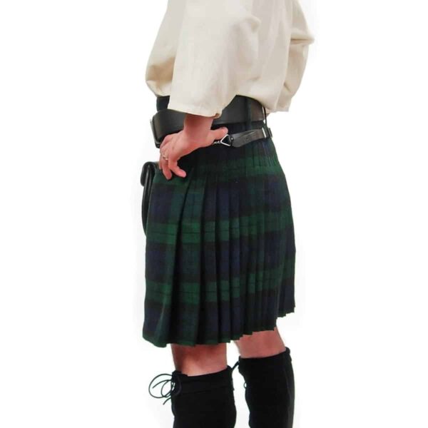 A woman in a plaid kilt is posing for a picture, showcasing the Black Watch Kilt and Sporran Rental Package.